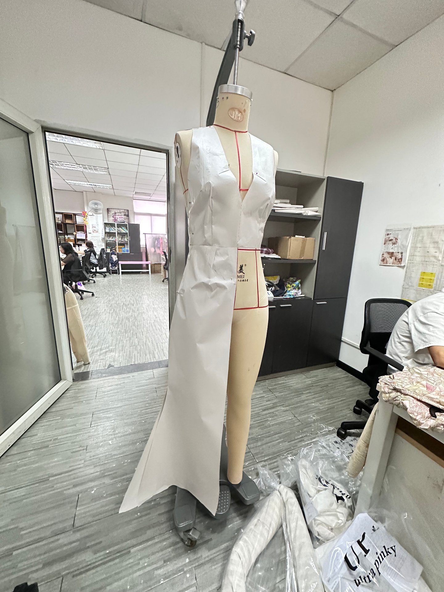 Paper toile pinned on the mannequin at UP Fashion Guangzhou — the shell prototype before real fabric