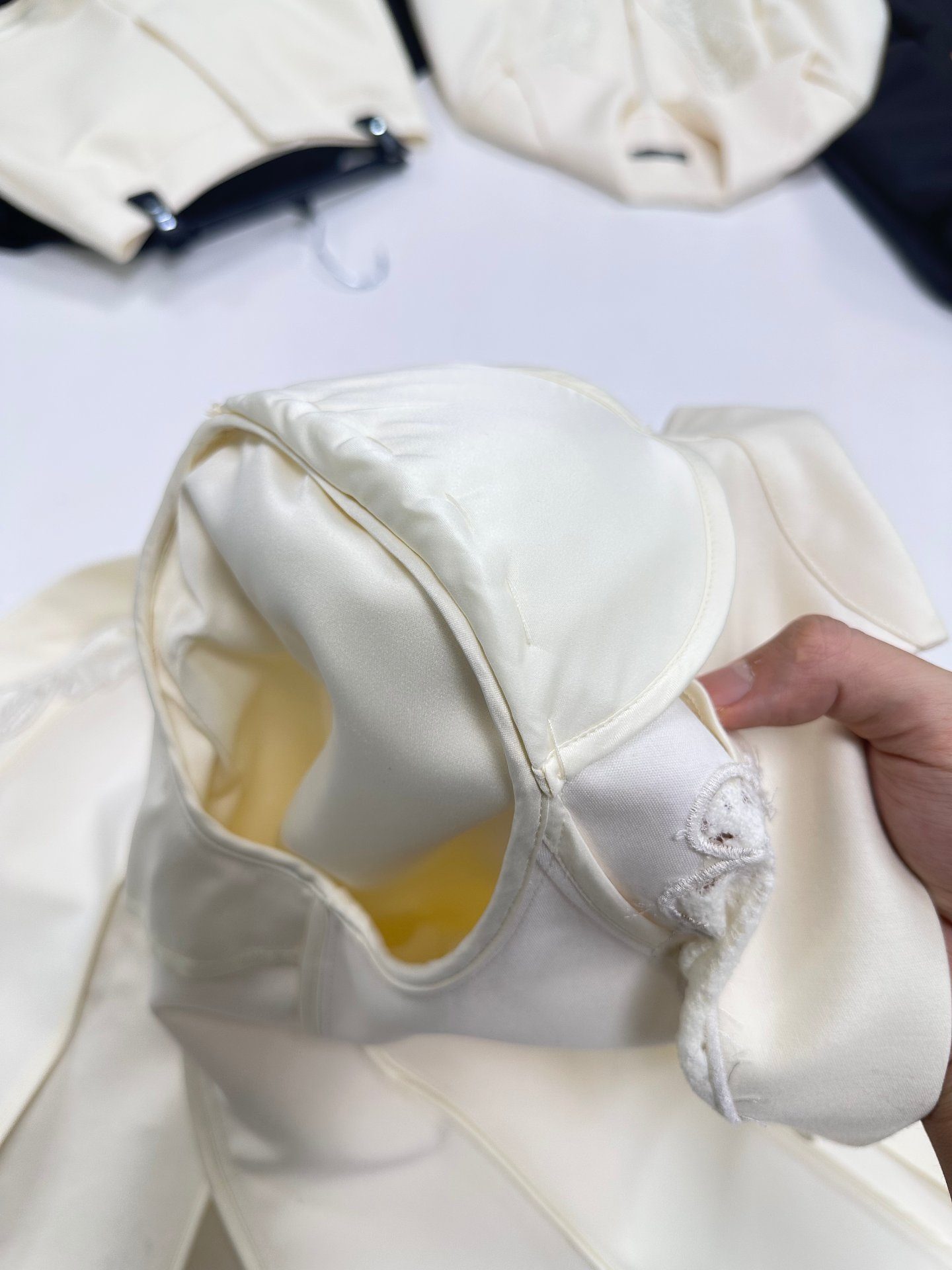 Shoulder pad set inside the shoulder of an unlined ivory blazer, UP Fashion Guangzhou