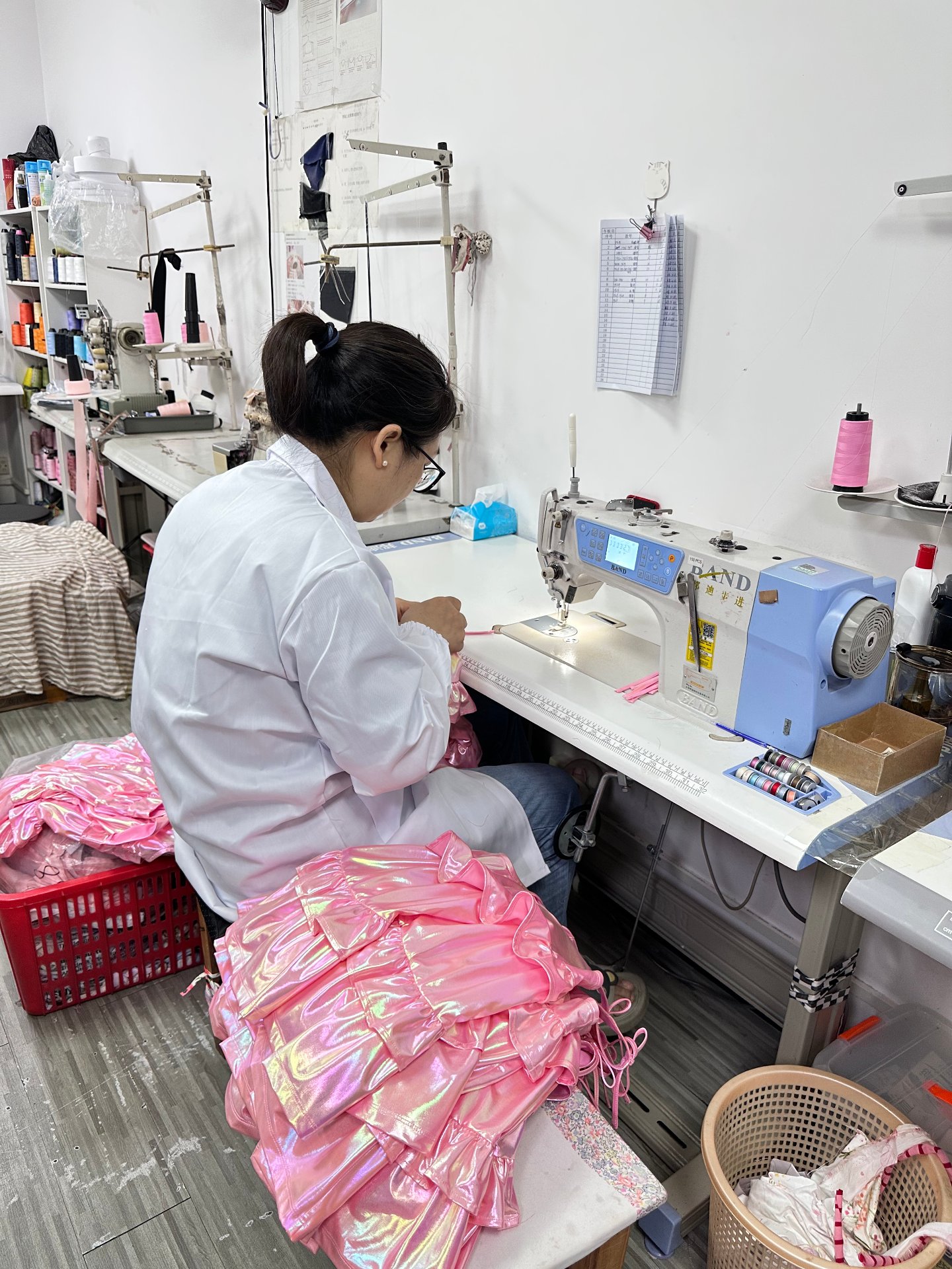 Sewing iridescent pink fabric at an industrial machine